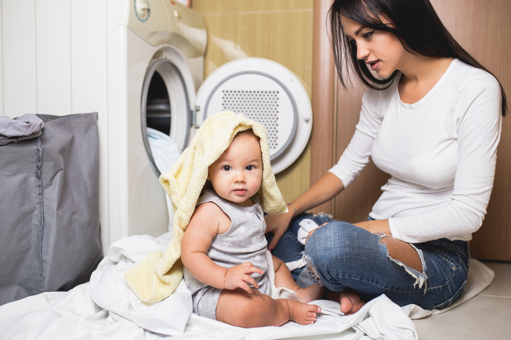 ibu dan bayi di depan mesin cuci