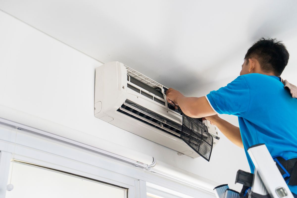 laki-laki memperbaiki ac